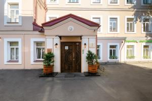 een gebouw met een deur met twee planten ervoor bij Ordynka Hotel in Moskou