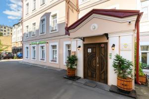 um edifício com uma porta de madeira numa rua em Ordynka Hotel em Moscou