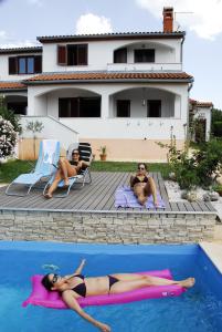 a woman laying on a raft in a swimming pool at Holiday Home Enisa in Vabriga