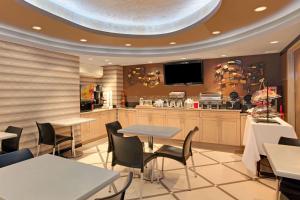 un restaurante con mesas y sillas y una cocina en Ramada by Wyndham Bronx en Bronx