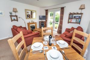 ein Wohnzimmer mit einem Holztisch und Stühlen in der Unterkunft Quaver Cottage in Keswick