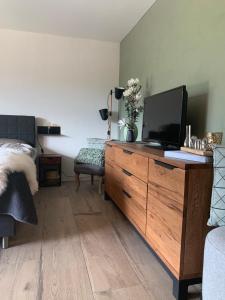 a bedroom with a dresser with a tv on it at FeWo Gotschna Haus Bargis in Klosters Dorf