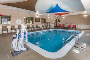 a pool at a hotel with chairs and tables at Comfort Inn Moline - Quad Cities in Moline