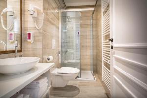 a bathroom with a toilet and a sink and a shower at Hotel Bellevue - Liburnia in Opatija