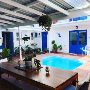 una piscina en un patio trasero con una mesa de madera y un sidx sidx sidx de mesa en BlueSky Arniston Guest House, en Arniston