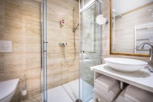 a bathroom with a glass shower and a sink at Hotel Bellevue - Liburnia in Opatija