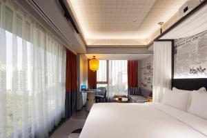 a hotel room with a bed and a window at Arthur Hotel Canton Tower Guangzhou-广州塔骑士物语酒店 in Guangzhou