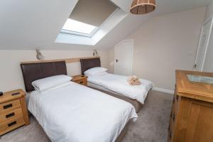 a bedroom with two beds and a skylight at Alison's View in Keswick