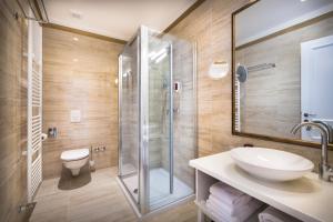 a bathroom with a shower and a sink and a toilet at Hotel Bellevue - Liburnia in Opatija