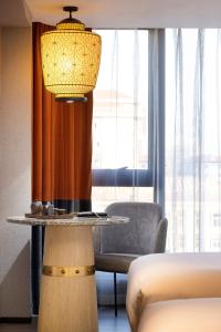 a table in a room with a bed and a lamp at Arthur Hotel Canton Tower Guangzhou-广州塔骑士物语酒店 in Guangzhou
