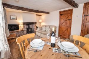 a dining room with a table and chairs and a couch at Jasmine Cottage in Portinscale