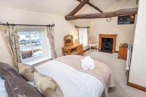 a bedroom with a bed and a fireplace at Jasmine Cottage in Portinscale