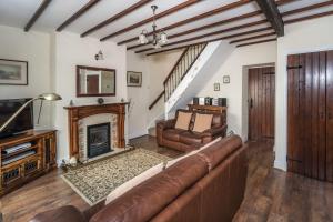 a living room with a couch and a fireplace at Millside Cottage in Braithwaite