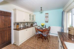a kitchen with a table and chairs in a room at Millside Cottage in Braithwaite