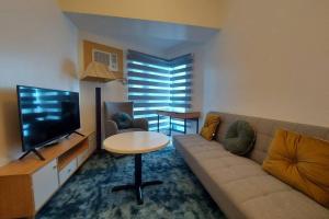 a living room with a couch and a table and a television at Magnificent View of Manila Bay, Roxas Blvd, US Embassy in Manila
