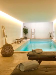 a swimming pool with two chaise lounges in a room at Hôtel Des Gouverneurs in Bastia