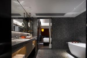 a bathroom with a bath tub and a sink at Arthur Hotel Canton Tower Guangzhou-广州塔骑士物语酒店 in Guangzhou