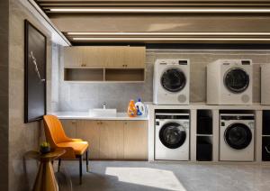 a kitchen with two washing machines and a sink at Arthur Hotel Canton Tower Guangzhou-广州塔骑士物语酒店 in Guangzhou