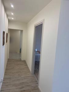 un couloir vide avec une porte menant à une chambre dans l'établissement LA CHIUSA Bed and Breakfast, à Montichiari