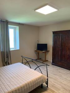 a bedroom with a bed and a cabinet and a window at LA CHIUSA Bed and Breakfast in Montichiari