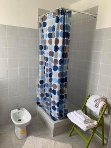 a bathroom with a shower curtain and a toilet at LA CHIUSA Bed and Breakfast in Montichiari