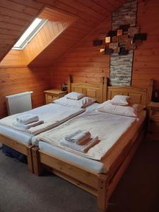 two twin beds in a room with a attic at Nábřežní terasy in Žďár nad Sázavou
