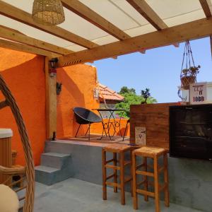 patio ze stołem, krzesłami i kominkiem w obiekcie Casa de Mikel w mieście Rodos
