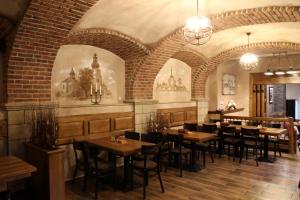 a dining room with tables and chairs and a brick wall at Nábřežní terasy in Žďár nad Sázavou
