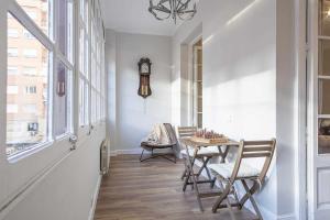 comedor con mesa, sillas y reloj en Apartment Lucia, en Barcelona