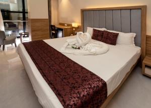 a bedroom with a large bed with towels on it at Hotel Suyog Residency in Navi Mumbai