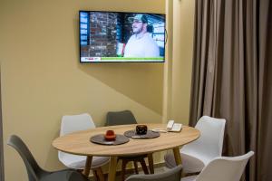 a dining room table with a television on it at Glyfada Beach Hotel in Glyfada