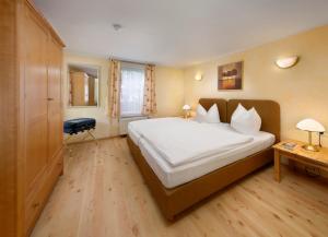 a bedroom with a large white bed and a desk at KNAUS Campingpark Leipzig in Leipzig