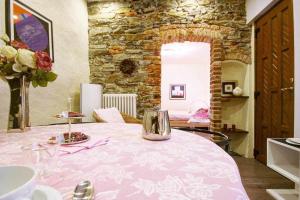 - une salle à manger avec une table rose et des fleurs dans l'établissement LA PERLA piccolo appartamento in piazza, à Orta San Giulio
