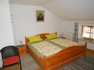 a bedroom with a wooden bed with yellow pillows at Lenzenhof, Familie Christian und Stefanie Spitzl in Frasdorf