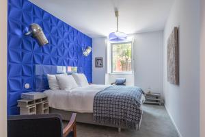 a blue bedroom with a bed and a blue wall at toctoctoc lisboa in Lisbon +188 photos