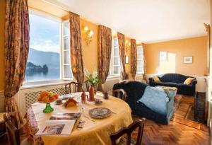 un soggiorno con tavolo e una grande finestra di Casa Orta appartamento con vista lago a Orta San Giulio