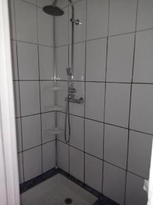 een douche in een wit betegelde badkamer bij Studio plain-pied in Montjaux