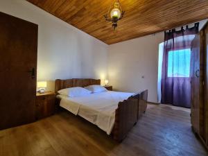 a bedroom with a large bed and a wooden ceiling at House Krnica 2120 in Krnica