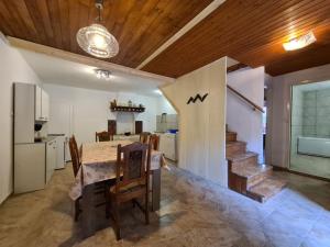 a kitchen and dining room with a table and a staircase at House Krnica 2120 in Krnica