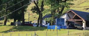 a building with cars parked in a field at 3 Dialknowe Holiday Cottage - Wanlockhead - 3 Bedrooms in Wanlockhead +2 photos
