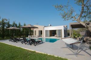 a villa with a swimming pool and lounge chairs at Sweet Villas in Lygia