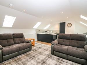 a living room with two chairs and a kitchen at Council Chambers at The Institute Executive Apartments in Keith