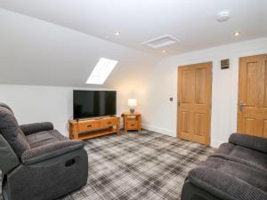 a living room with two chairs and a flat screen tv at Council Chambers at The Institute Executive Apartments in Keith