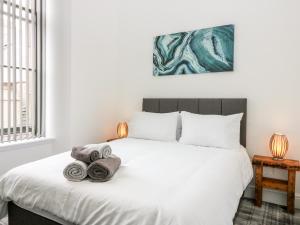 a bedroom with a white bed with towels on it at Council Chambers at The Institute Executive Apartments in Keith