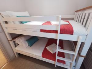 two bunk beds in a room with a bed at Fell View Cottage in Cockfield