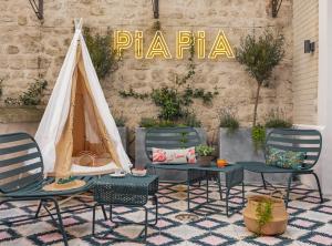 une terrasse avec des chaises, une table et une tente dans l'établissement Hôtel Piapia, à Paris