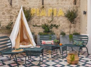 a patio area with chairs, tables and umbrellas at Hôtel Piapia in Paris