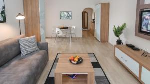 ein Wohnzimmer mit einem Sofa und einem Tisch in der Unterkunft New Belgrade Apartment Delta City in Belgrad