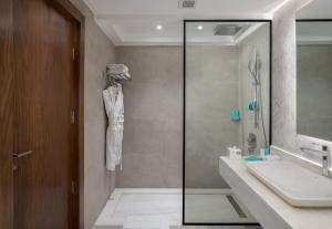 a bathroom with a shower and a sink and a mirror at Al Masa Hotel Nasr City in Cairo