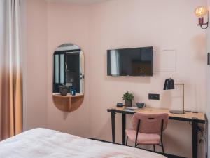 a hotel room with a bed and a television at Hôtel Piapia in Paris